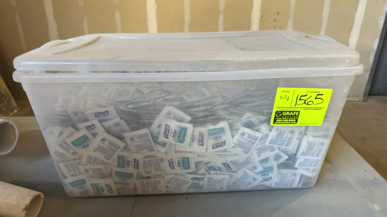 Plastic storage tote with lid filled with individually packaged Purell sanitizing wipes.