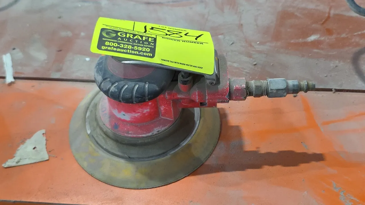 Pneumatic random orbital palm sander. Features lever paddle throttle, quick-connect air fitting, and round backing pad. Note: Rubber shroud exhibits c