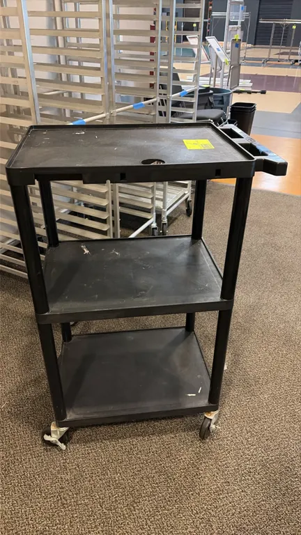Buhl 3-tier portable poly cart. Features molded plastic construction, three shelves, integrated push handle, and top shelf cable pass-through hole. Mo