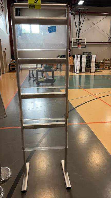 Freestanding literature display rack. Features a silver-tone metal frame with 4 tiered clear acrylic pamphlet pockets. Freestanding base with dual sta