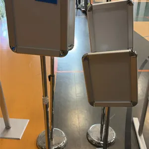 Adjustable sign stands. Features front-loading snap frames with rounded chrome corners and telescoping height-adjustable poles. Mounted on round chrom
