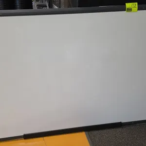 Quartet dry erase whiteboard. Features a dark gray frame and attached marker tray. Dimensions: 72"W x 48"H.