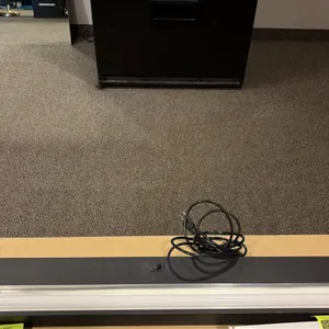 Under-counter task light fixture. Features black housing, integrated rocker switch, installed fluorescent tube, and attached power cord with standard 