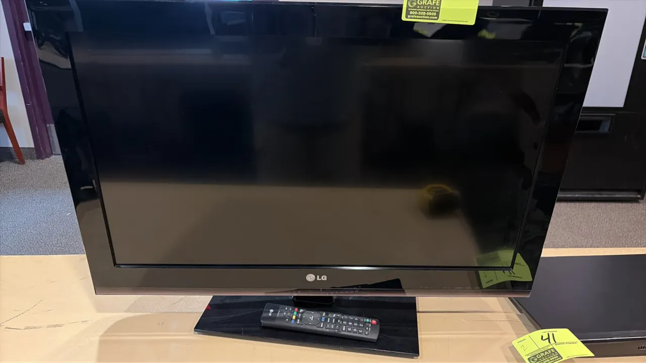 LG 32" flatscreen TV. Includes remote control. Mounted on tabletop stand. Note: Power cord is not included.