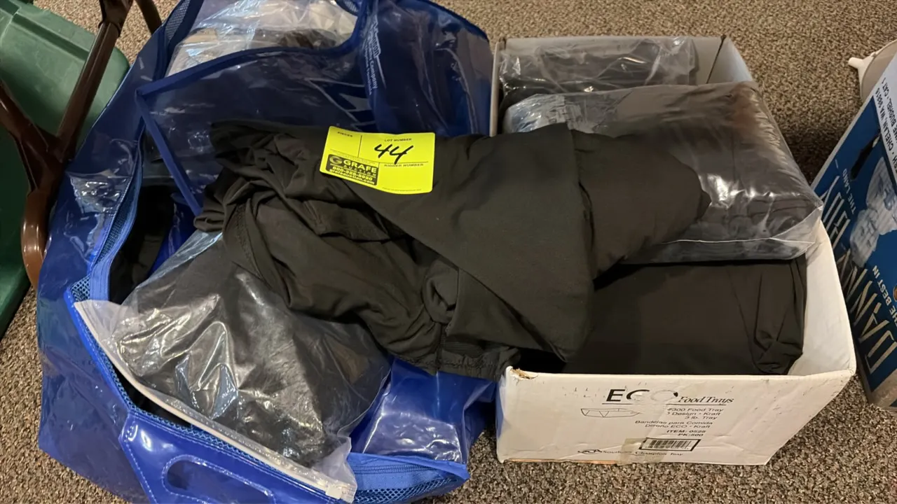Black fabric stage skirting. Includes assorted black stage skirting sections, individually bagged pieces, and a blue zippered storage bag.