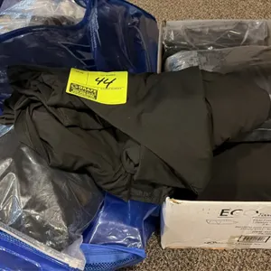 Black fabric stage skirting. Includes assorted black stage skirting sections, individually bagged pieces, and a blue zippered storage bag.