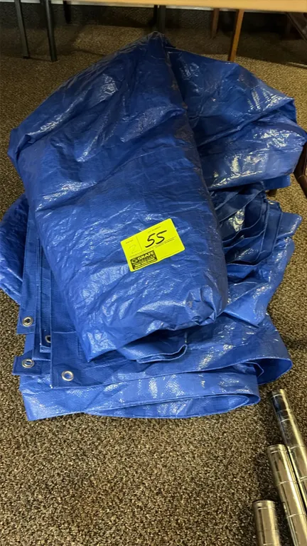 Blue poly tarps. Features woven polyethylene construction, reinforced hemmed edges, and metal grommets. Shelving posts in foreground not included.