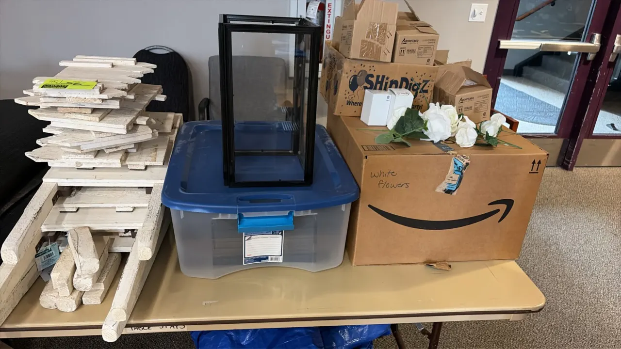 Event decor package. Includes a black metal and glass display lantern, artificial white flowers, rustic whitewashed wood decor pieces, a plastic stora