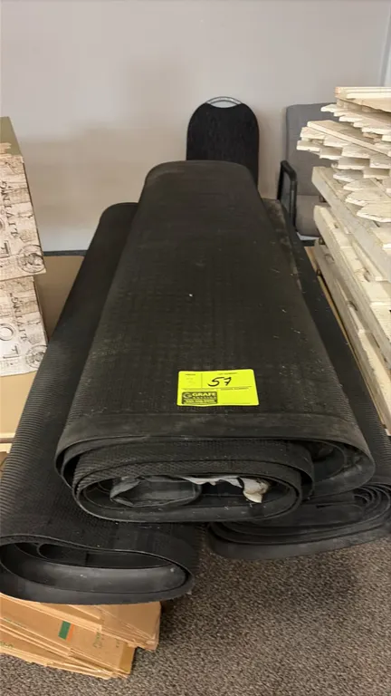 Rubber-backed area rugs. Features a dark textured carpet top with rubber backing and perimeter edging.