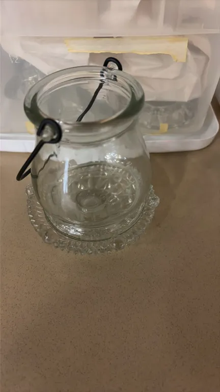 Assorted glass candle holders. Includes hanging glass jar with wire bail handle and clear pressed glass candle holder bases. Storage tote not included