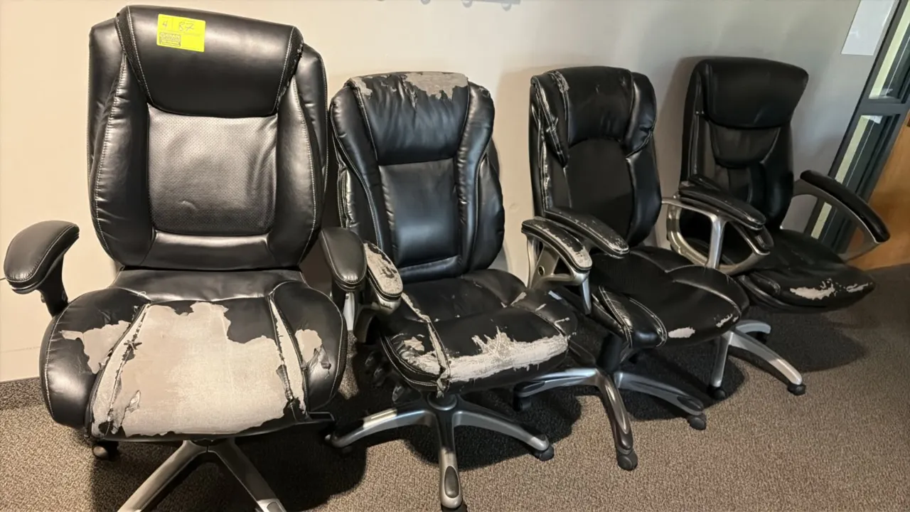Executive office chairs. Features black faux leather upholstery and padded armrests. Mounted on 5-star caster bases. Note: Upholstery shows heavy peel