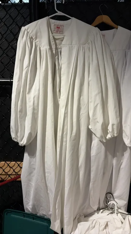 Murphy white robes. Lot includes approximately 20 robes in assorted sizes. Features white fabric construction with front pleating and gathered cuffs.