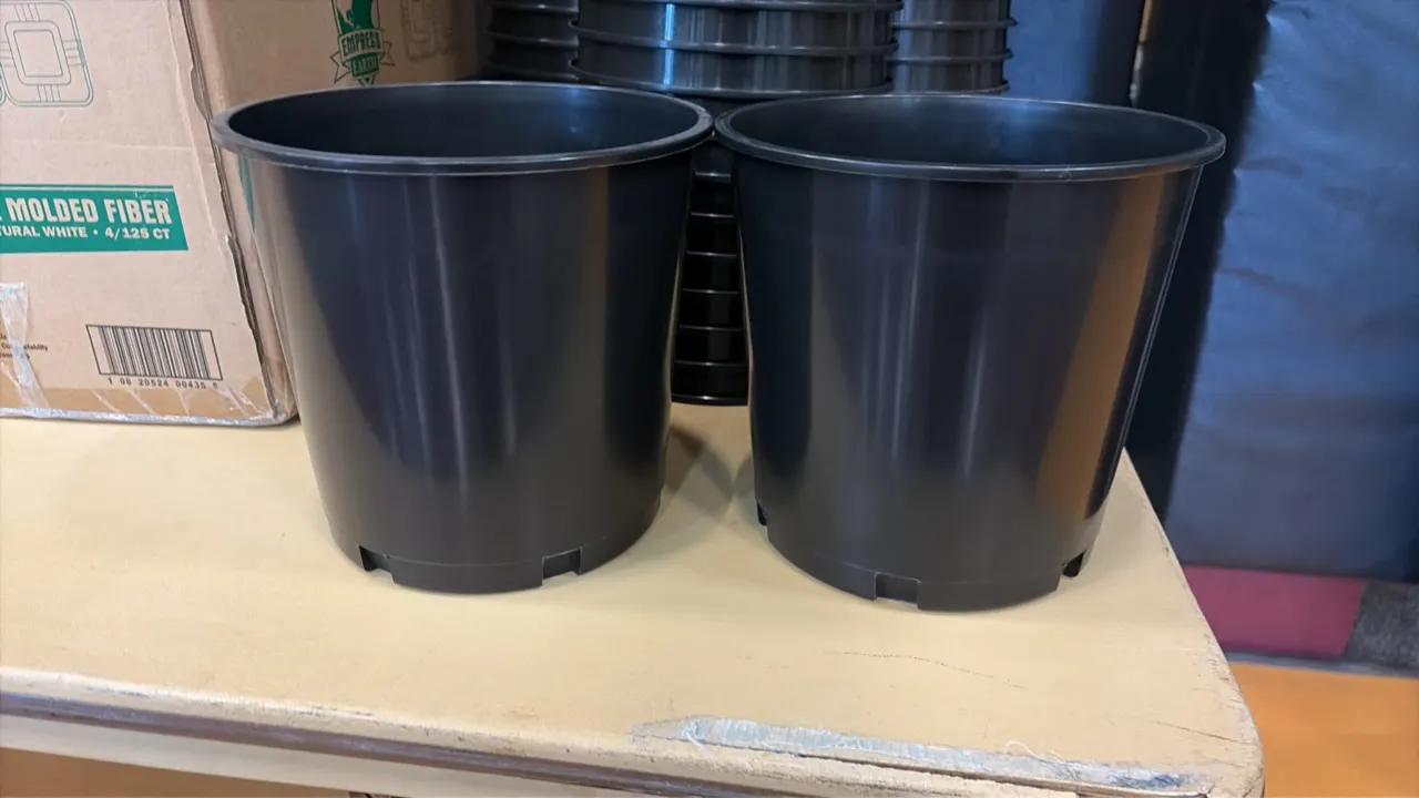 Black plastic buckets. Features molded plastic construction, rolled rims, and recessed base channels. Stackable design.