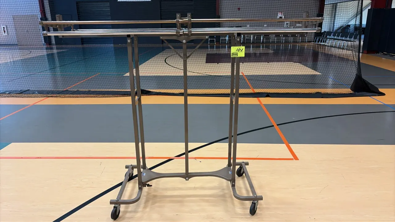 Portable folding coat rack. Features durable metal construction with an integrated upper shelf and hanging rails. Mounted on four swivel casters.