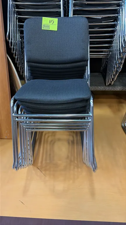 Stacking chairs. Features gray patterned cloth upholstered seat and back. Chrome-finished sled base frame. Stackable design.