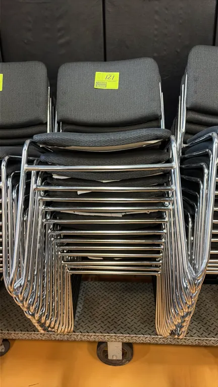 Gray cloth stacking chairs. Features gray patterned fabric upholstered seats and backrests, armless design, and chrome sled base frames. Stackable for