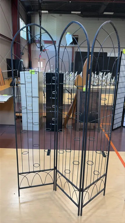 Black metal 3-panel folding floral or candle screen. Features hinged construction, arched trellis top, decorative base scrollwork, and integrated circ