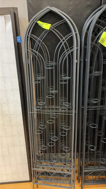 Black metal arched candle and floral holder screens. Features gothic arch design, multiple integrated circular ring holders for candles or floral arra
