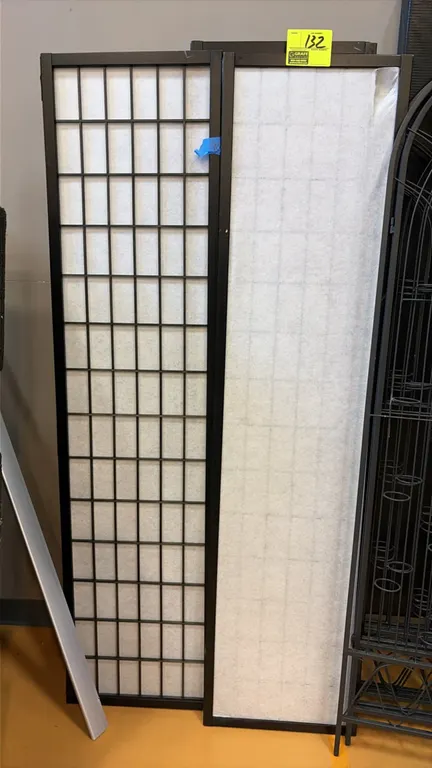 Shoji-style folding room divider screen. Features black wood frame construction with translucent grid paneled screens and multi-panel folding hinges.