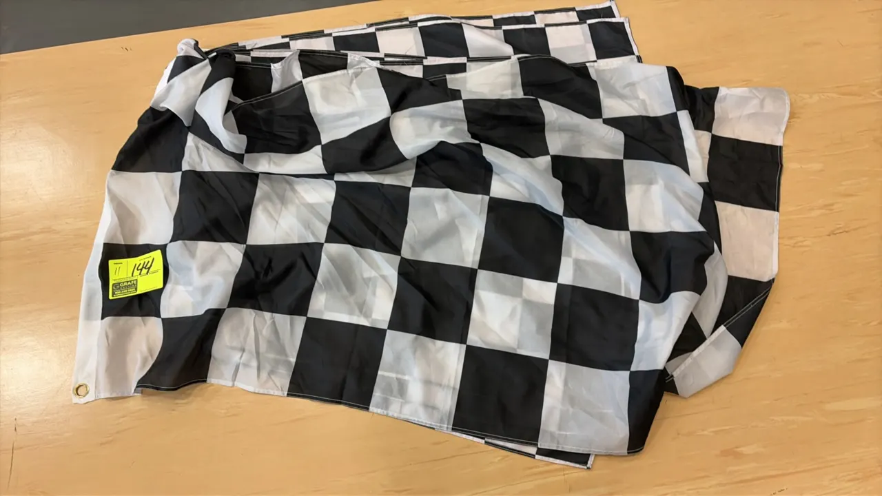 Checkered flags. Features black and white checkered pattern with metal grommets for mounting.