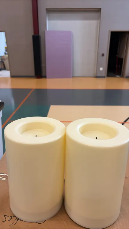 Large LED flameless pillar candles. Features cream-colored cylindrical bodies with recessed faux wick LED styling. Battery operated. Includes cardboar