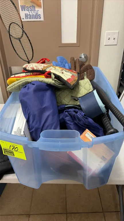 Assorted recreation and kitchen items lot. Includes board games, assorted potholders and oven mitts, plastic bats, footballs, badminton rackets, (5) a