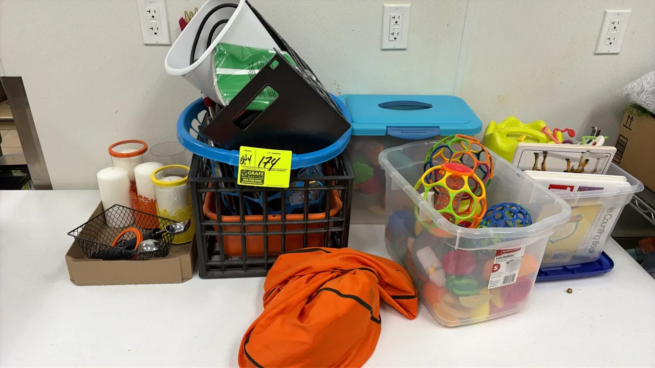 Assorted miscellaneous lot. Includes pillar candles with glass holders, wire basket, children's toys, board books, plastic storage totes, and a milk c