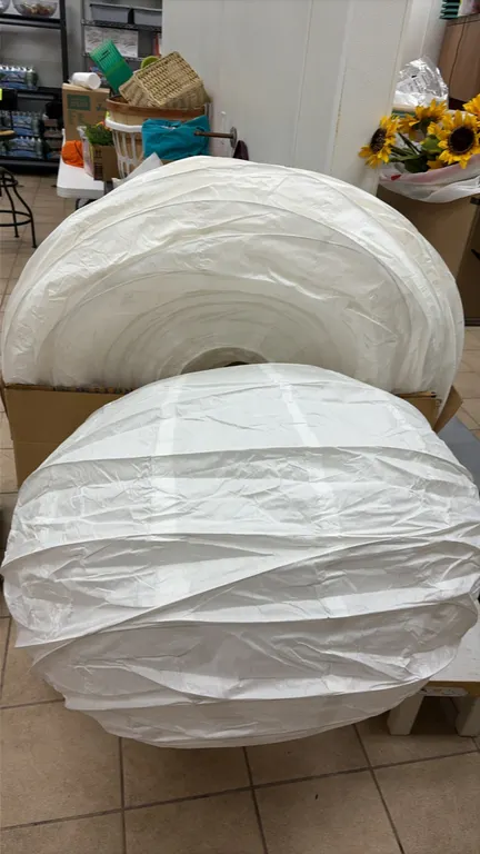 White collapsible paper lanterns. Features round accordion-style construction with wire framing.