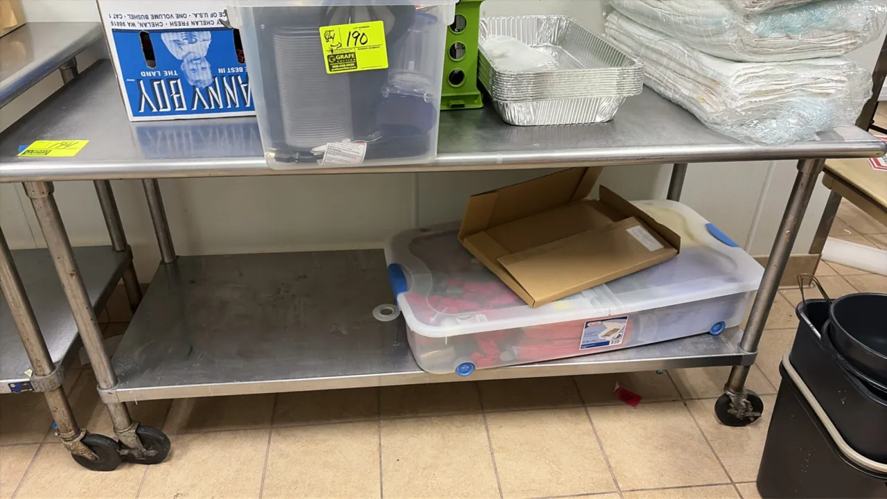 Stainless steel portable work table. Features a lower undershelf. Dimensions: 72" x 30". Mounted on casters. Contents not included.