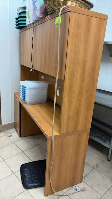 Wood laminate desk with overhead hutch. Features upper 4-door storage cabinet, under-cabinet task lighting, and a 3-drawer pedestal. 64" x 24". Conten