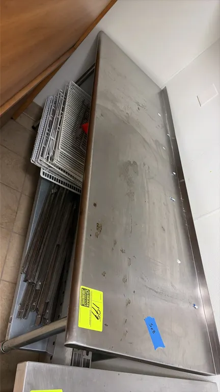 Stainless steel work table. Features a rear backsplash, lower undershelf, and included stainless rails. Dimensions: 72" x 24". Mounted on tubular legs