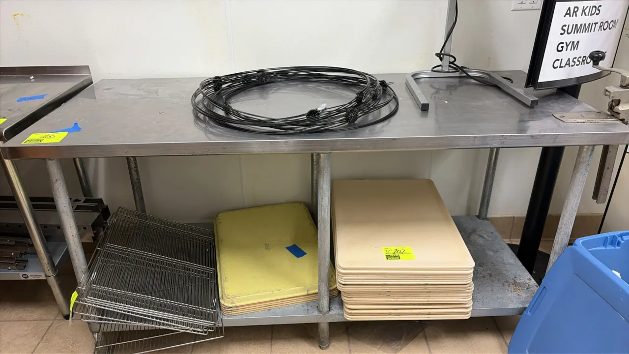 Stainless steel work table. Features a flat top and galvanized undershelf. Dimensions: 72" x 30". Mounted on galvanized tubular legs with adjustable b