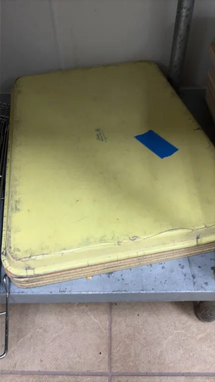 Assorted fiberglass food service display trays. Features molded rectangular construction with low rims in beige and yellow finishes.
