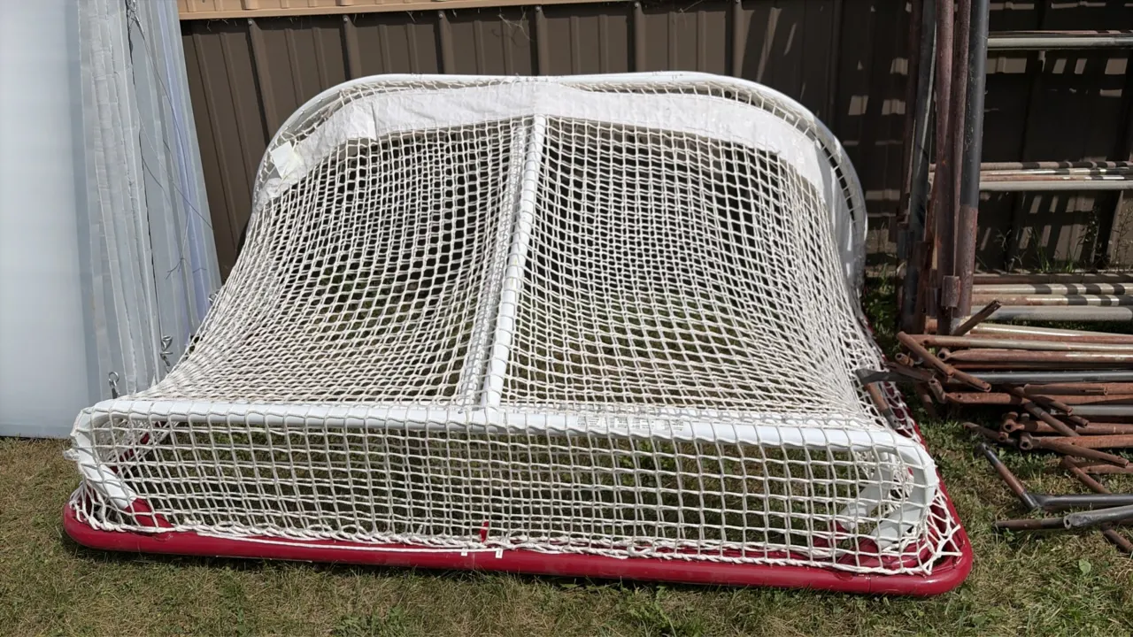 Hockey goalie nets. Features tubular steel construction with red powder-coated base frames, heavy-duty white mesh netting, and top shelf framing with