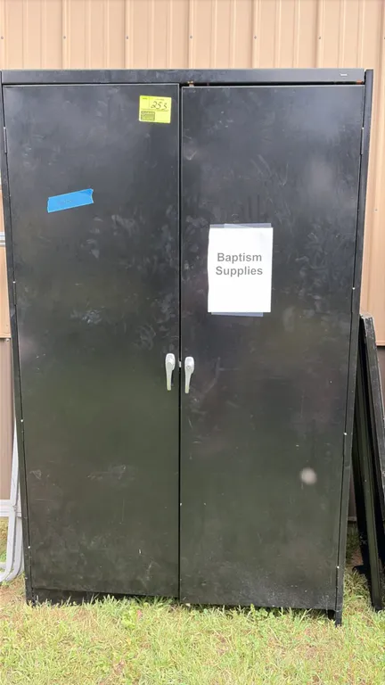 Metal 2-door storage cabinet. Features dual swing doors with handles and a black painted finish. Note: Key not included.