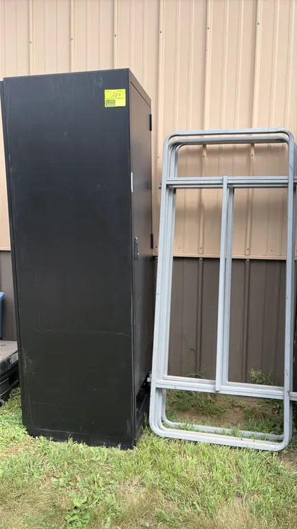 Metal computer cabinet and stage rails. Includes (1) tall black metal computer cabinet with a single hinged front door and latch handle, along with (3