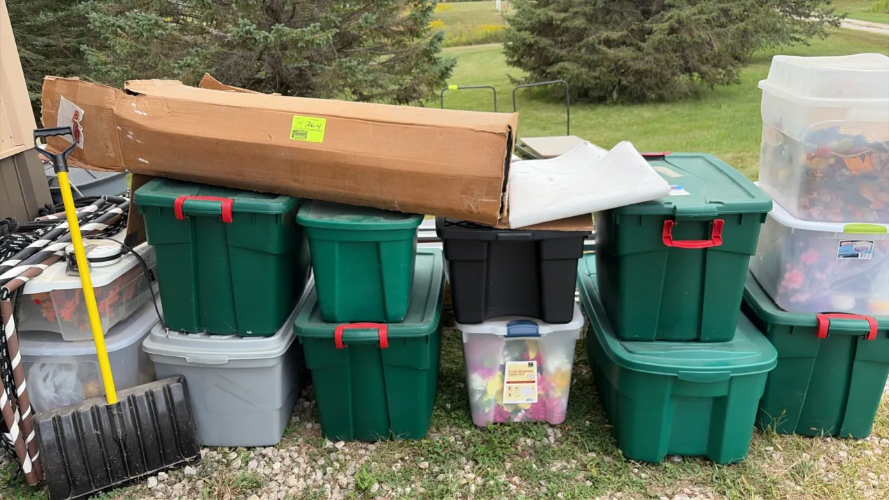 Assortment of plastic storage totes containing assorted seasonal decor. Includes holiday greenery with string lights, artificial florals, fall decorat