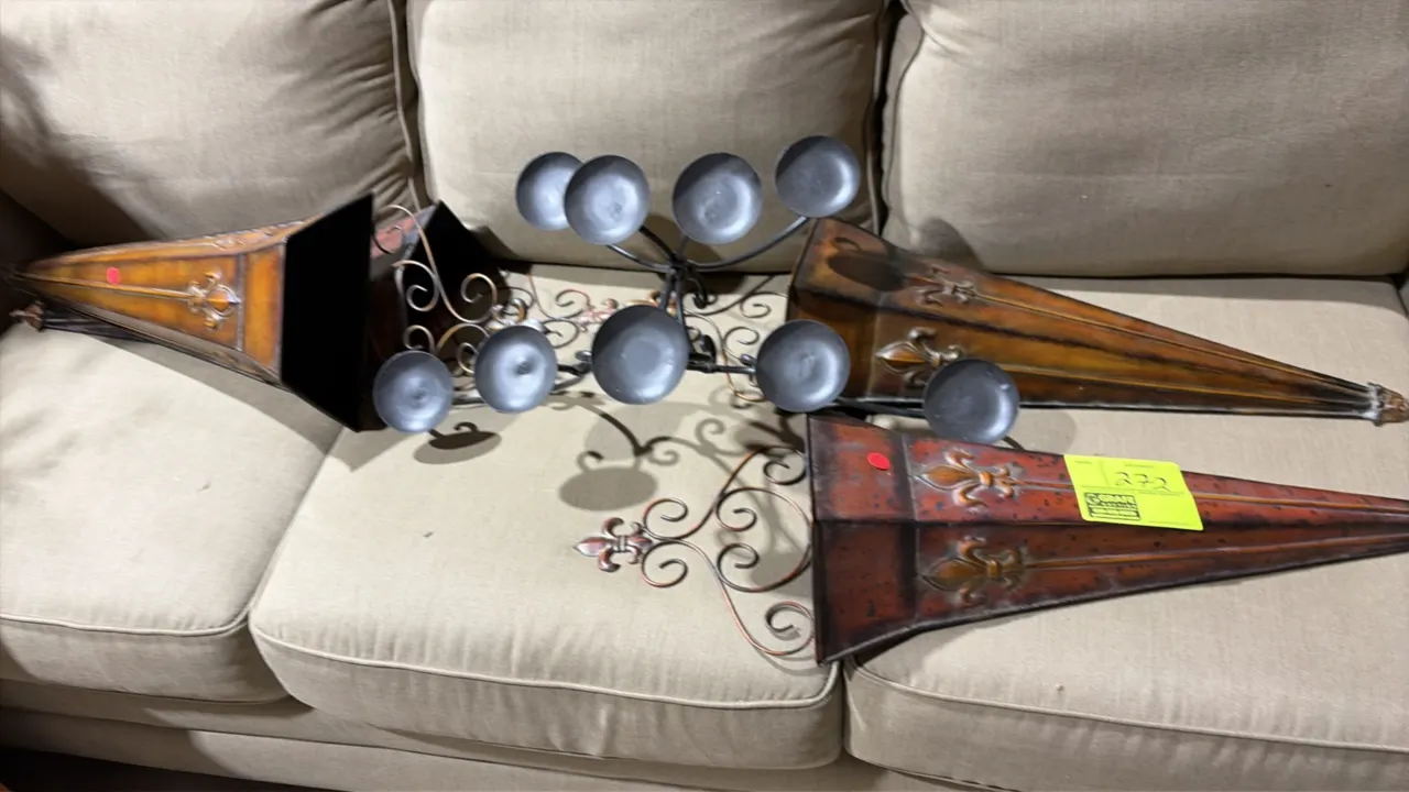 Assorted metal wall decor and artificial wreaths. Includes metal cone-shaped wall pocket sconces with fleur-de-lis accents, scrollwork metal candle sc