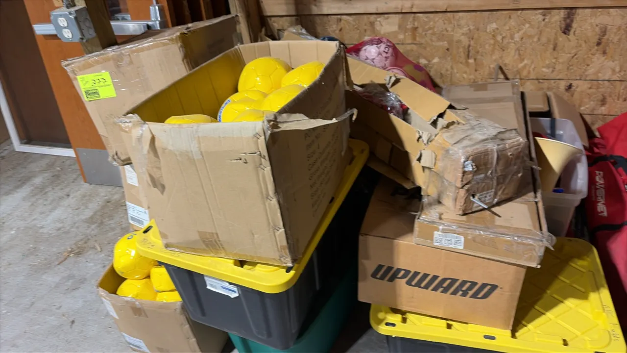 Sports equipment assortment. Includes soccer balls, sports nets, cheer megaphones, yard line markers, and assorted field accessories. Packaged in card