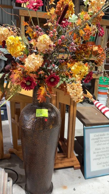 Hammered tin floral floor vases. Features textured metal construction with flared necks and pedestal bases. Includes artificial autumn floral and foli