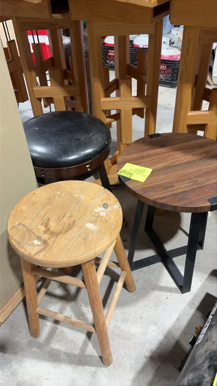Assorted stools and side table lot. Includes (1) round side table with woodgrain-finish top and black metal base, (1) round natural wood stool, and (1