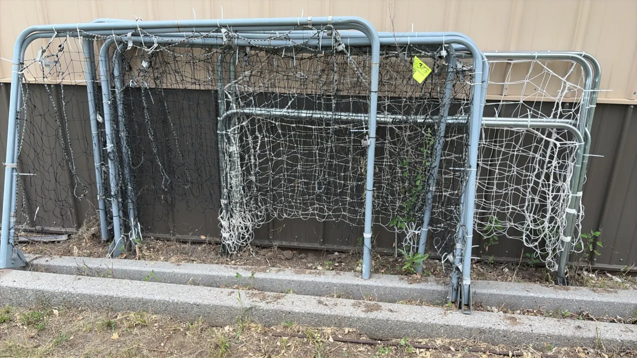 Portable soccer goal frames with netting. Features tubular metal frame construction with attached black and white mesh netting.