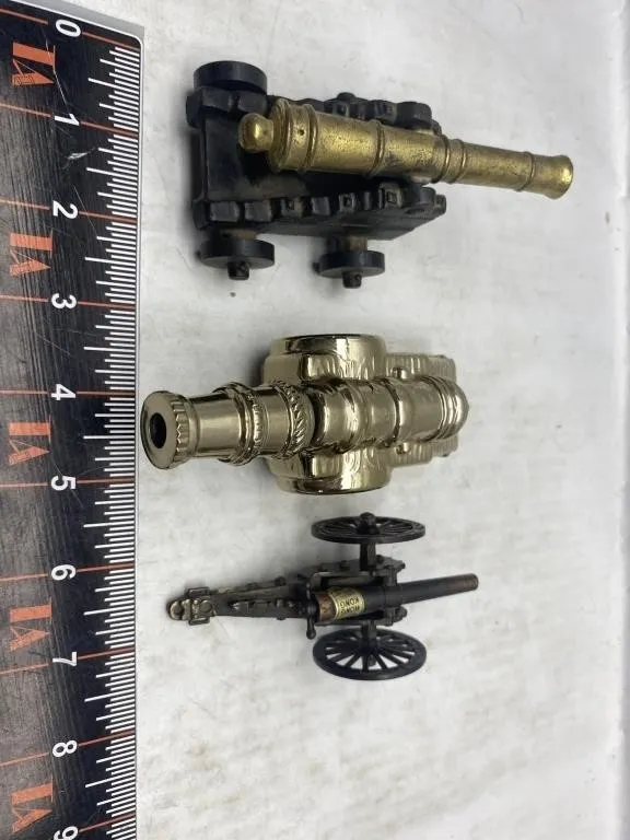 Three miniature brass/gold-tone cannon models