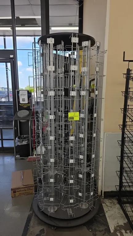Rotating metal card merchandiser. Features multi-column wire display pockets, round top canopy, and revolving carousel assembly. 77"H. Mounted on a ci