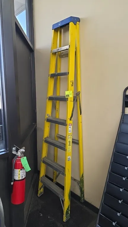 Louisville 8' fiberglass A-frame stepladder. Features non-conductive yellow fiberglass side rails, aluminum steps, molded blue top cap with tool slots