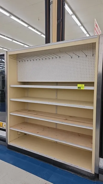 Wood shelving display unit. Features an upper pegboard section with display hooks, 4 adjustable shelves with tag channel molding, and a fixed base she