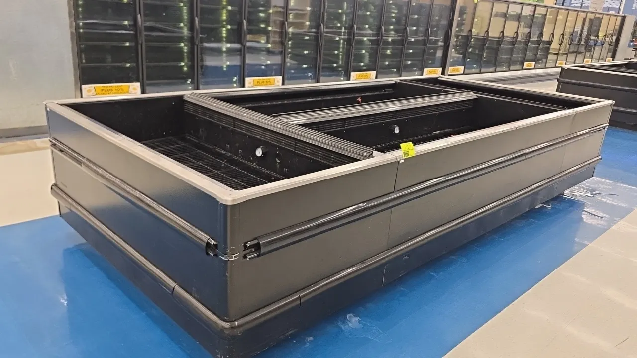 2009 Hussmann FW-8 U double-wide frozen food island merchandiser cases with end bunkers. Features wire rack decking, dial thermometers, and black exte