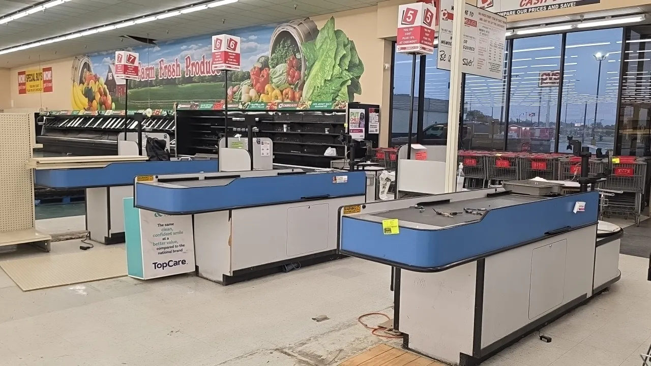 Laminate single-belt checklanes. Features motorized conveyor belts, blue and black protective bumper trim, cashier workstations with under-counter sto
