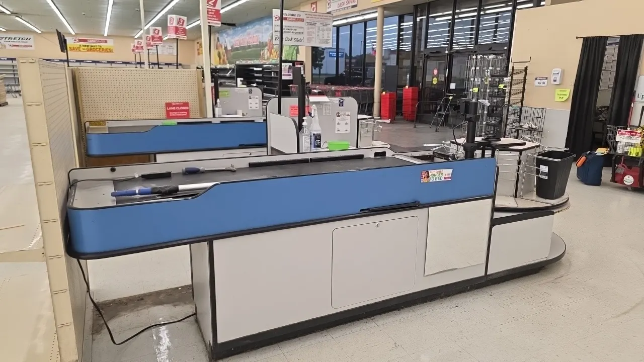 Laminate single-belt checklanes with rotating bag stations. Features motorized conveyor belt, 4' rotating carousel bag station with wire bag racks, bl