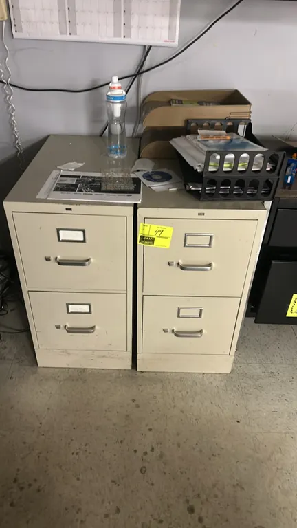 Metal 2-drawer vertical filing cabinets. Features pull handles with thumb latches and integrated label holders. Putty finish. Contents not included.